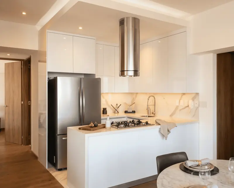 Cocina blanca con campana de acero, obra de Luis Llano