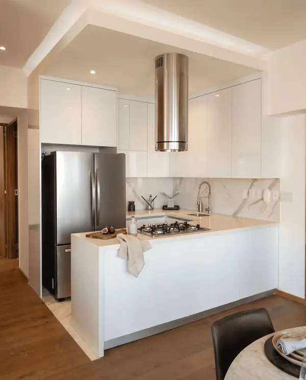 Cocina blanca con campana de acero, obra de Luis Llano