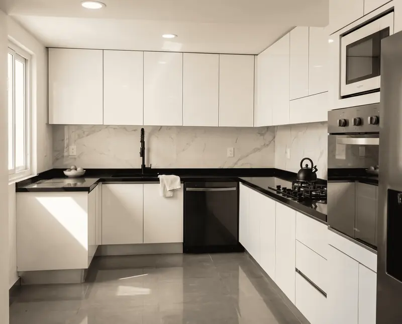 Cocina blanca en U con cubierta oscura, obra de Luis Llano